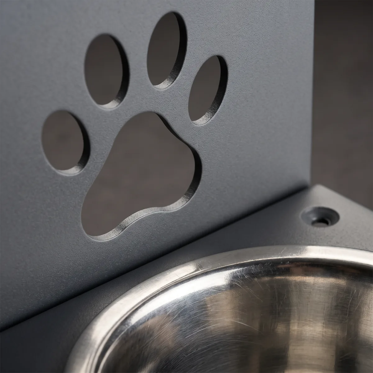 Detalle del recorte con forma de huella de perro en la placa de acero del comedero